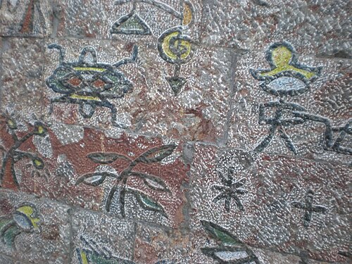 Dongba pictographs painted on a stone wall on Qiyi Street, Lijiang